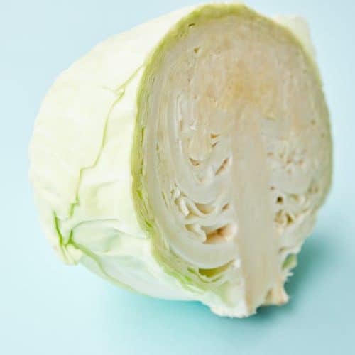 a head of cabbage halved and ready to cut.